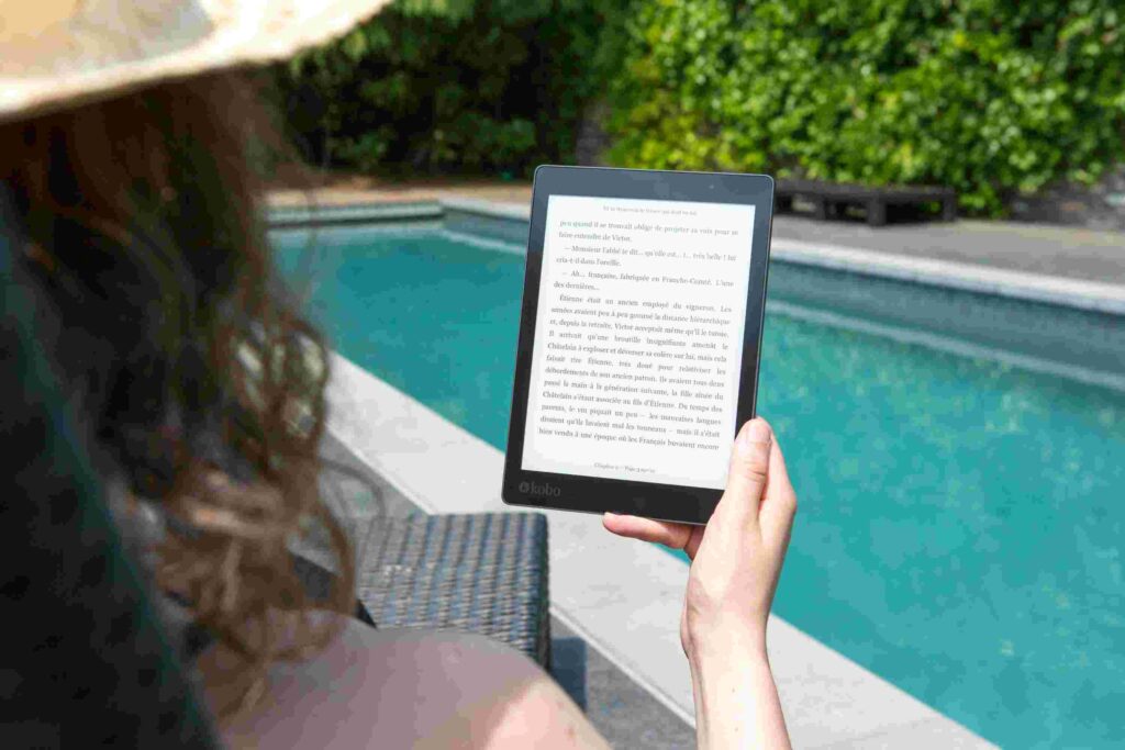 A Lady Reading eBook Beside a Pool